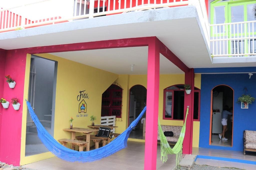 una casa colorida con una hamaca al aire libre en Fica, Vai ter Bolo Hostel en Itajaí
