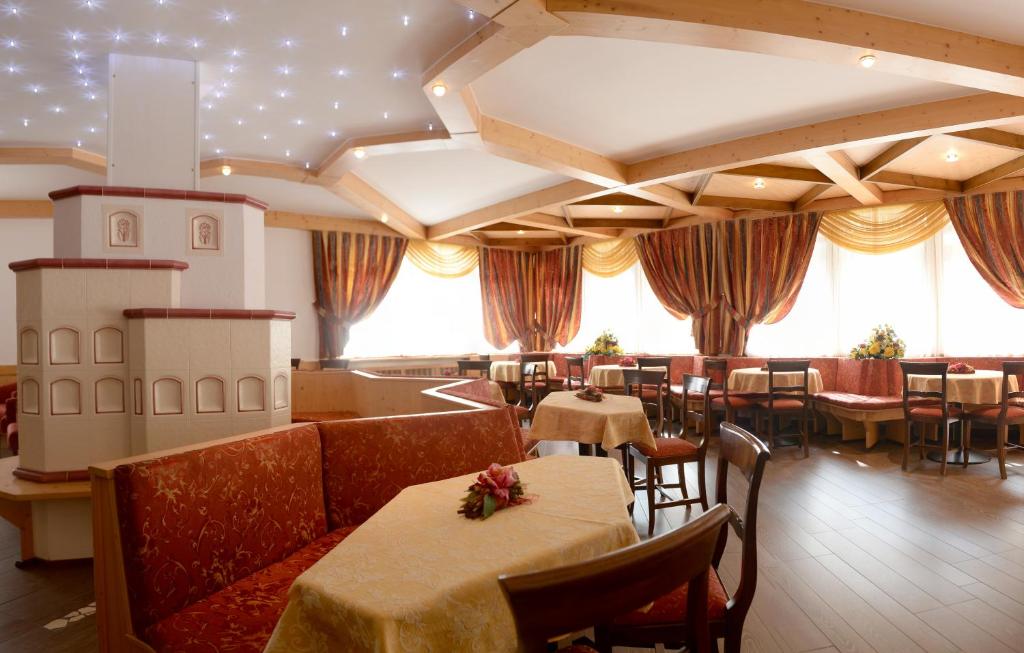 restauracja ze stołami i krzesłami w pokoju w obiekcie Hotel Dalla Serra w mieście Mezzana