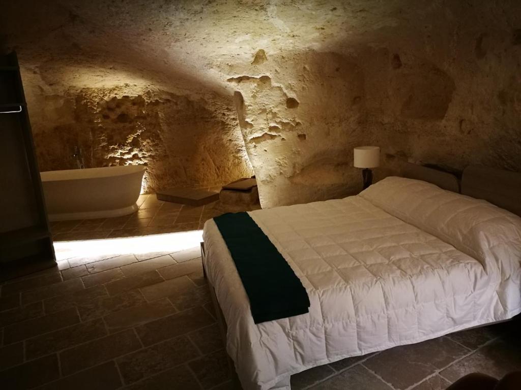 
a bed in a small room with a wall at 5 Elementi Sassi Matera in Matera
