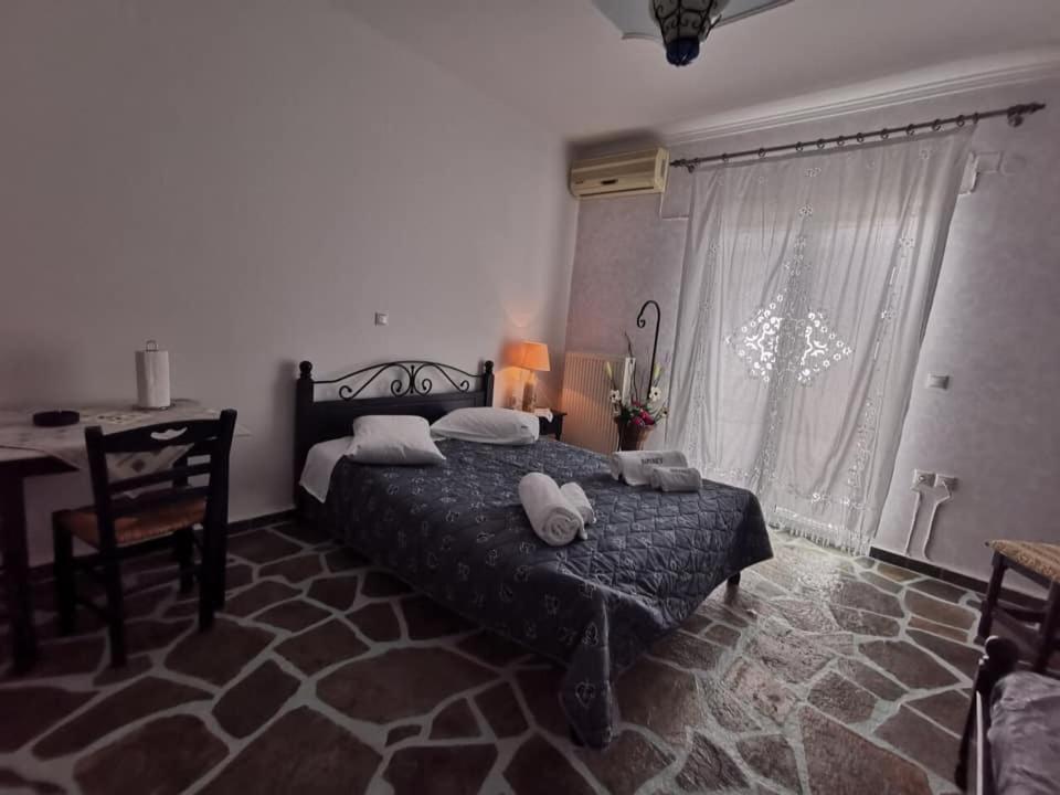 een slaapkamer met een bed, een bureau en een raam bij Sirines in Vlachata