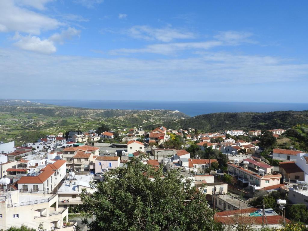 a view of a town with the ocean in the background at Hill View Hotel Apartments in Pissouri