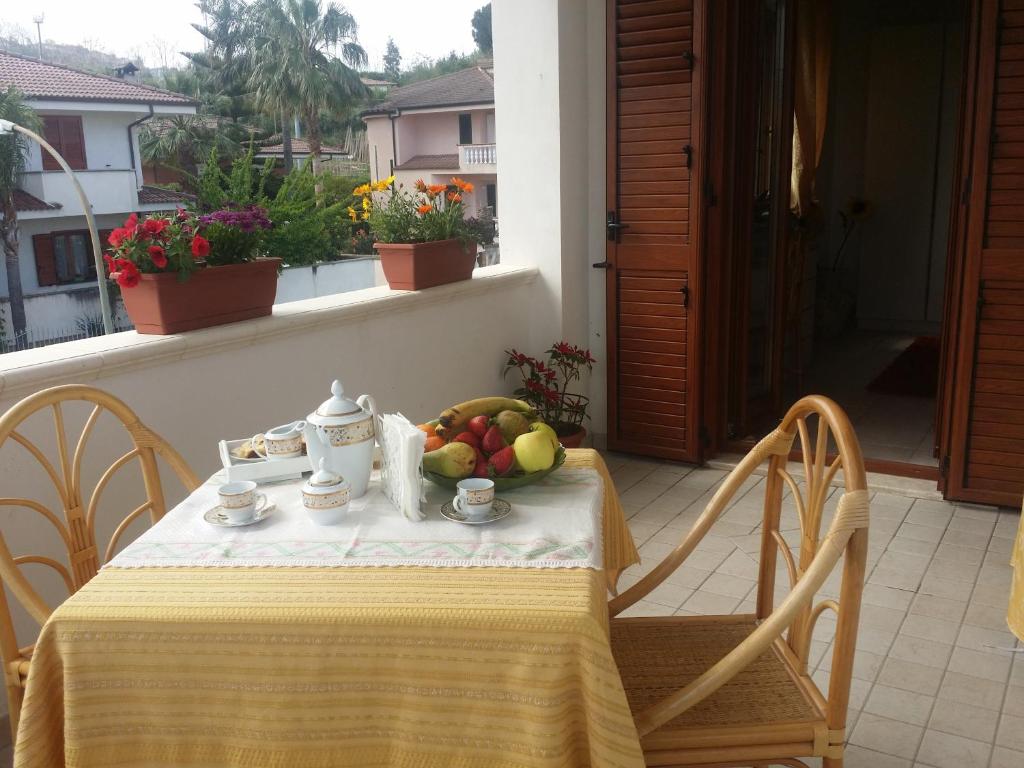 a table with a bowl of fruit on a balcony at Villa G&G in Tropea
