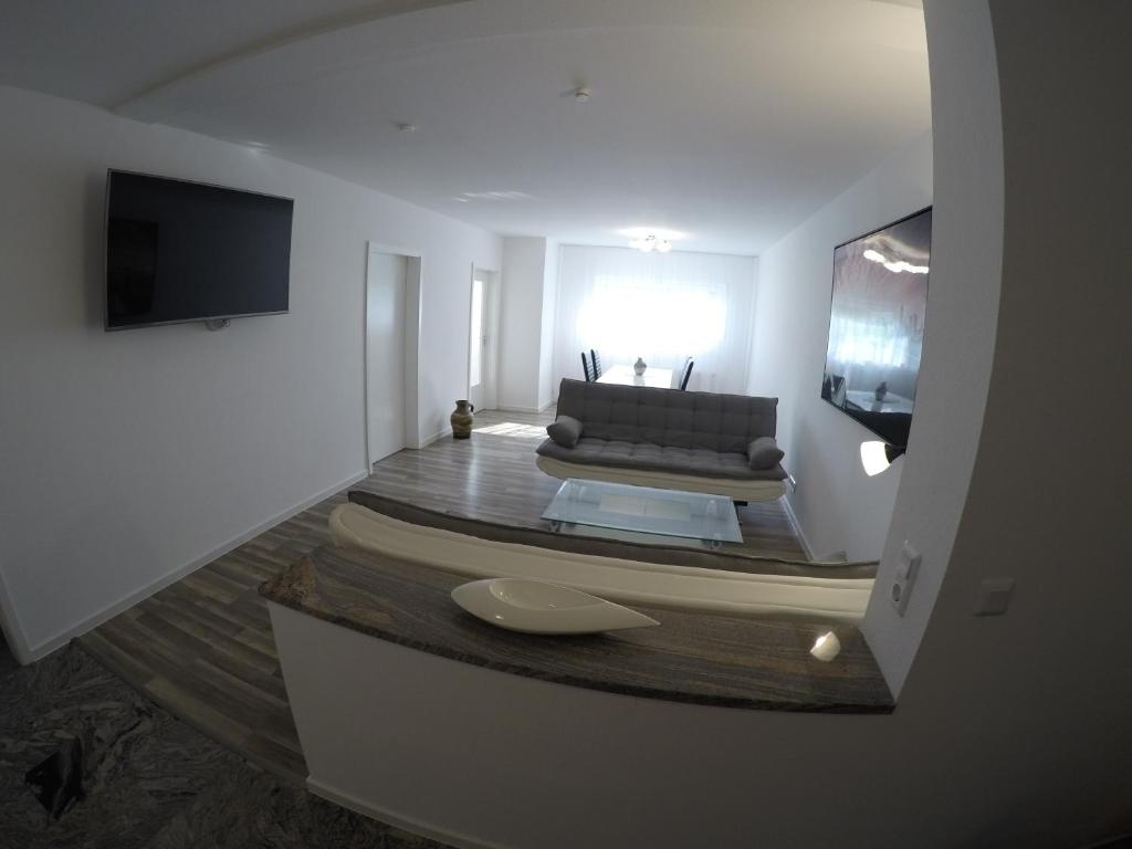 ein Wohnzimmer mit einem Sofa und einem Flachbild-TV in der Unterkunft Ferienwohnung Hecker in Rastatt