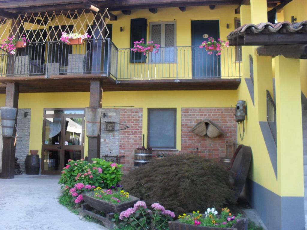 żółty dom z balkonem i kwiatami w obiekcie C' Era Una Volta w mieście Canelli