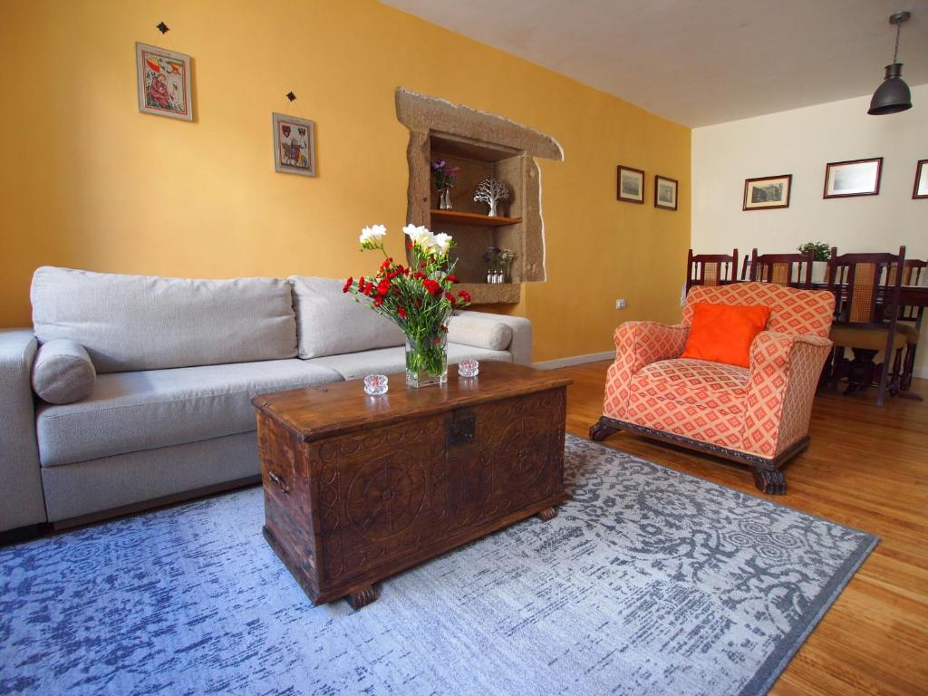 ein Wohnzimmer mit einem Sofa und einem Tisch in der Unterkunft Casco Histórico Apartamentos - Old Town Apartments in Santiago de Compostela