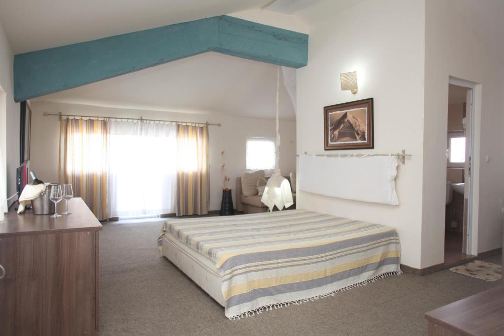 a bedroom with a bed and a blue ceiling at Hotel Laguna in Lozenets