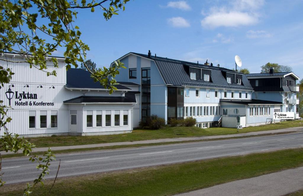 une rangée de bâtiments blancs sur le côté d'une route dans l'établissement Hotell Lyktan, à Arjeplog