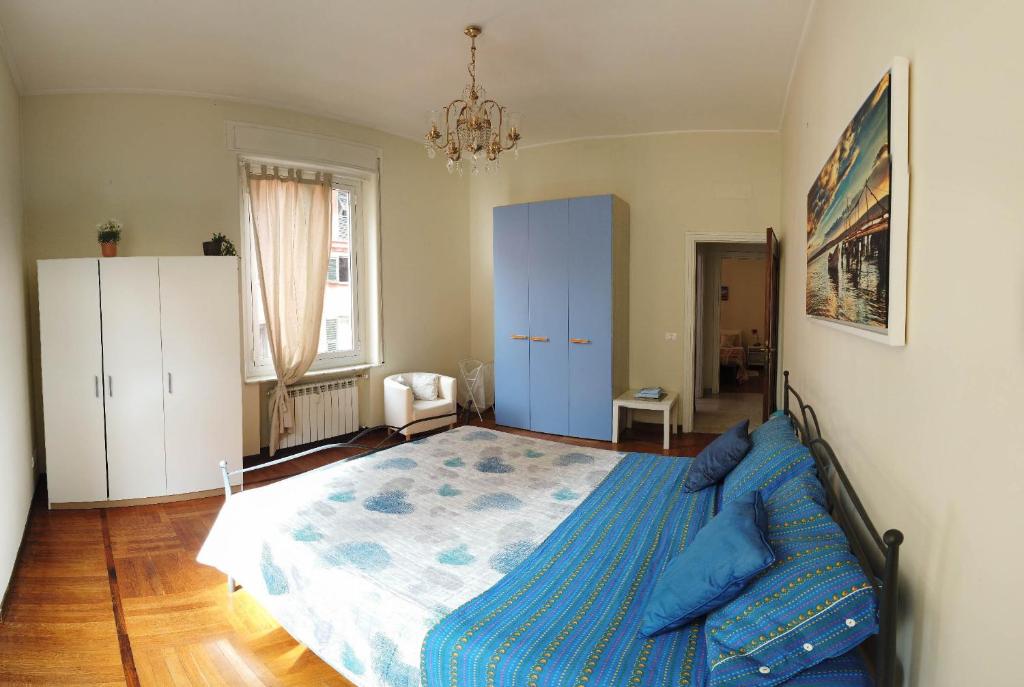 Un dormitorio con una cama azul y una lámpara de araña. en Assarotti Centre Apartment en Génova
