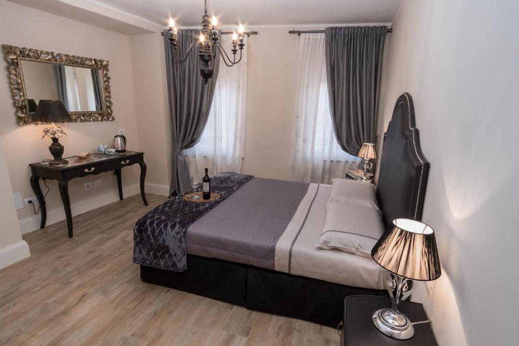 a bedroom with a bed and a table and a mirror at Pistoia Luxury Suite in Pistoia