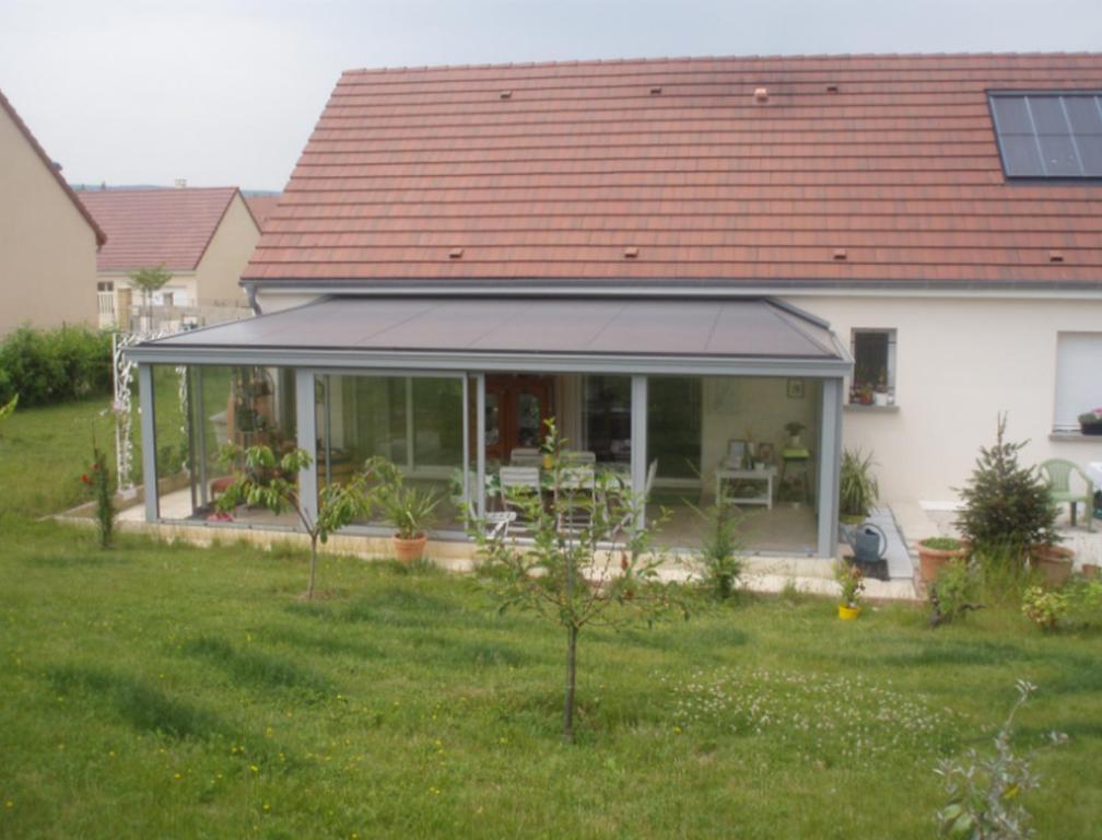 a house with a conservatory with a roof at Chambre d'Hôte de la Belle Jardinière in Chagny