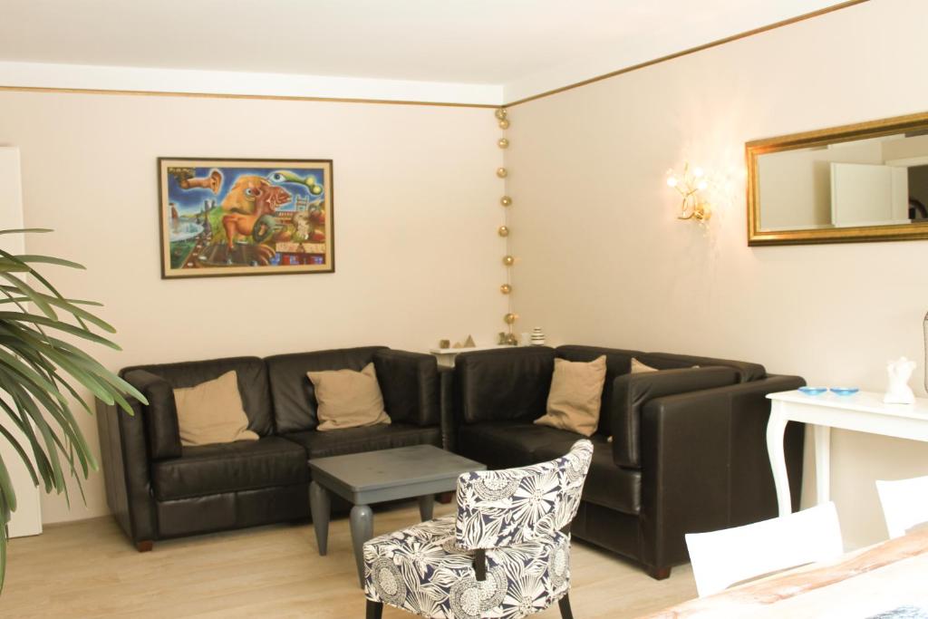 sala de estar con sofá negro y mesa en Siddy Apartment, en Reikiavik
