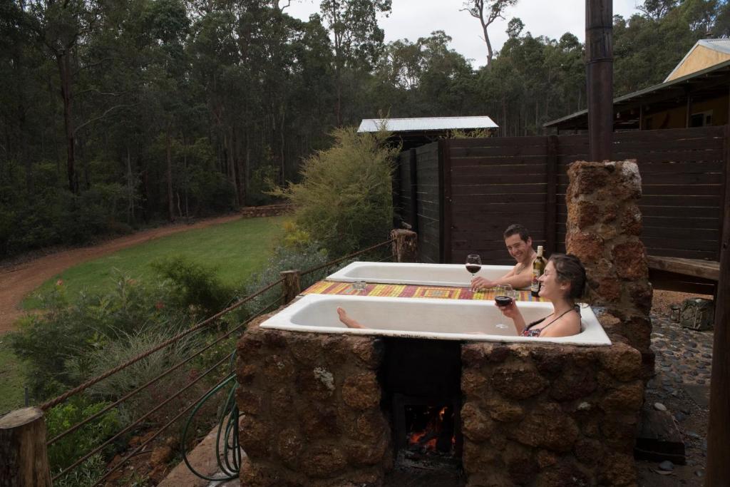 a man and woman sitting in a bath tub at Nannup Bush Retreat in Nannup