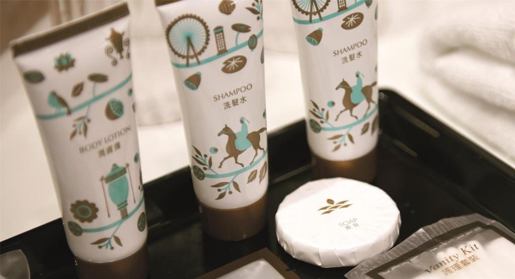 A close-up shows branded bathroom toiletries arranged beside folded towels.