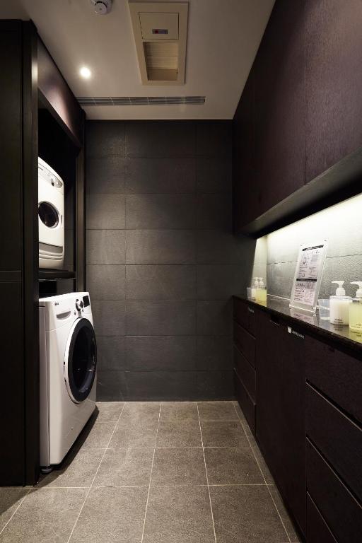 a laundry room with a washer and dryer at The Tango Taichung in Taichung