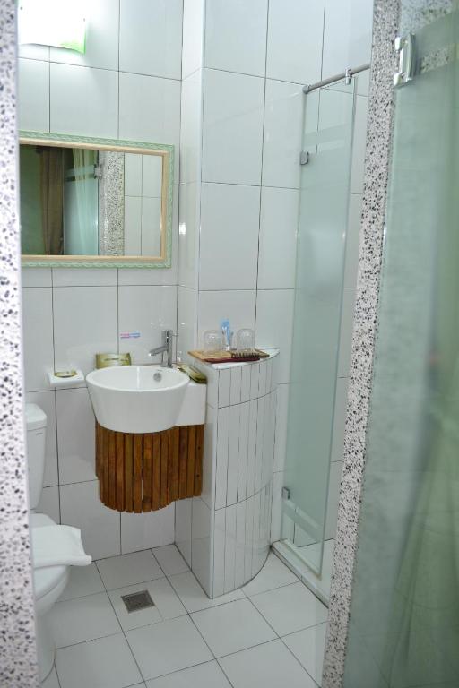 a white bathroom with a sink and a shower at Remember Sea View B&amp;B in Huxi