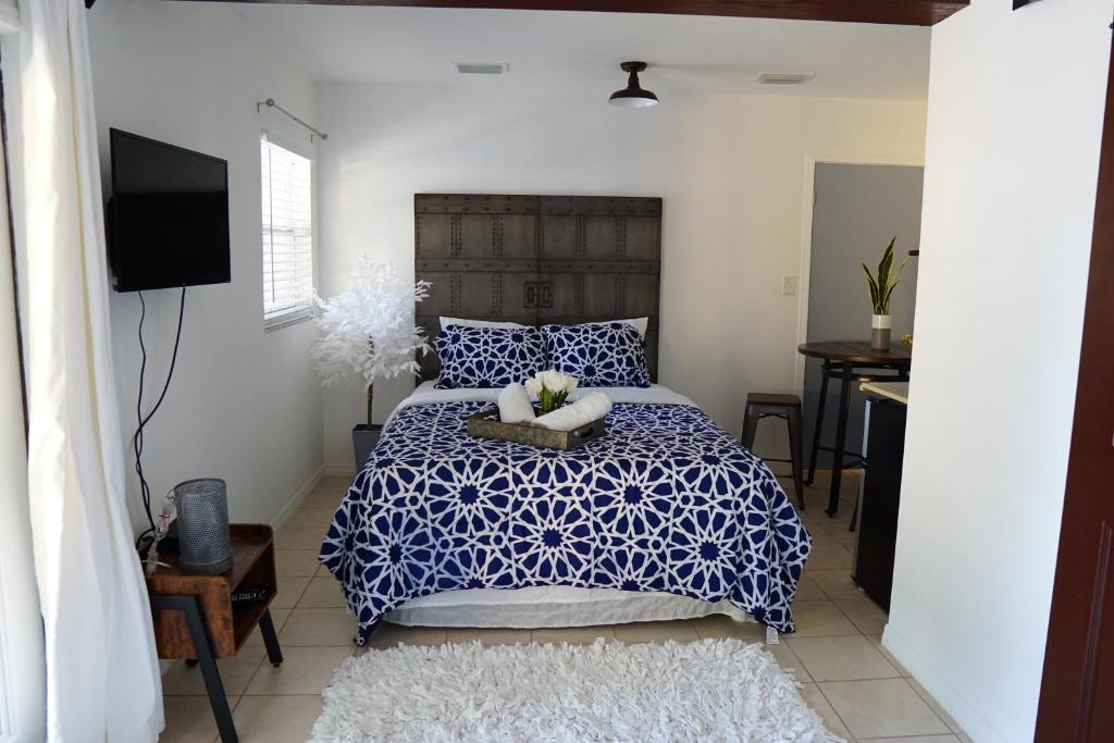 a bedroom with a blue and white bed and a television at Mi Casa Es Tu Casa, Airport Suites in Tampa