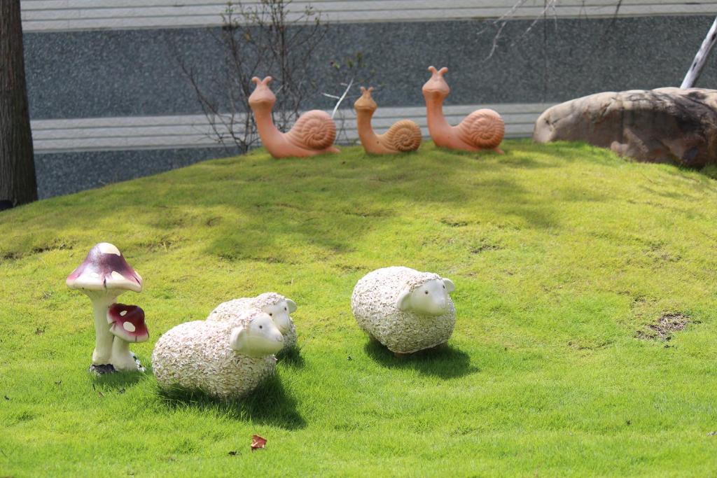 a group of stuffed animals sitting on top of a grass field at Yilan Pine Villa Homestay in Luodong