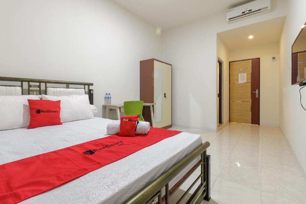 PampangにあるRedDoorz near AP Pettarani 3のベッドルーム1室(大型ベッド1台、赤い枕付)