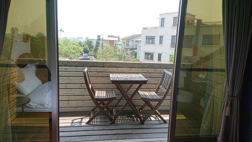 a balcony with a table and two chairs on a patio at Yilan Pine Villa Homestay in Luodong