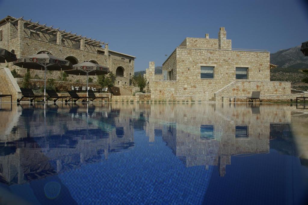 uma piscina de água em frente a um edifício em Anaxo Resort em Riglia