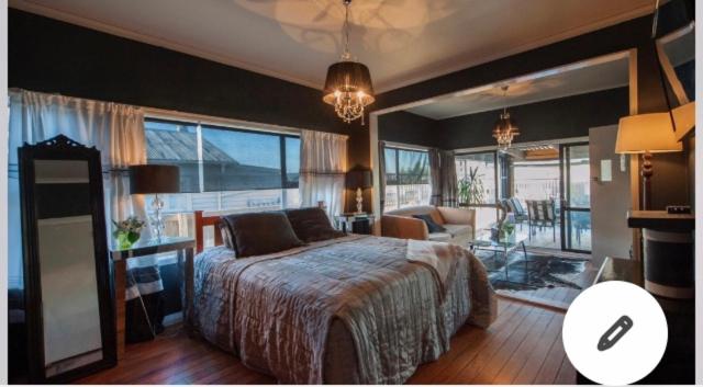 a bedroom with a bed and a living room at Skyline SkyRides Premium Property in Rotorua