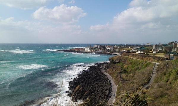 an aerial view of the ocean and a coastline at 6pm Pension in Jeju