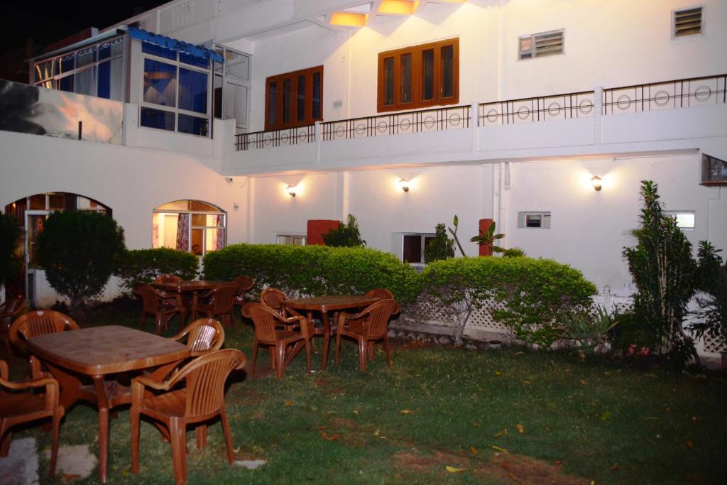 a patio with tables and chairs in front of a building at Hotel Sugandh Retreat Jaipur in Jaipur