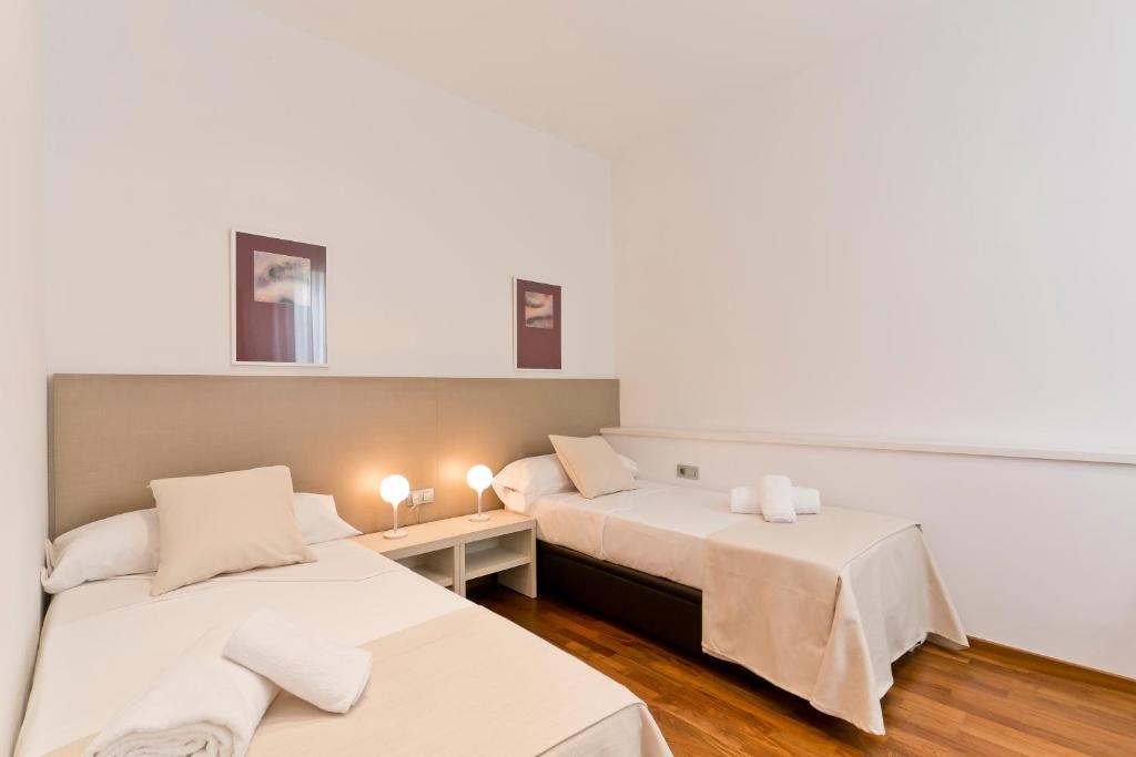 Posteľ alebo postele v izbe v ubytovaní Aspasios Rambla Catalunya Apartments