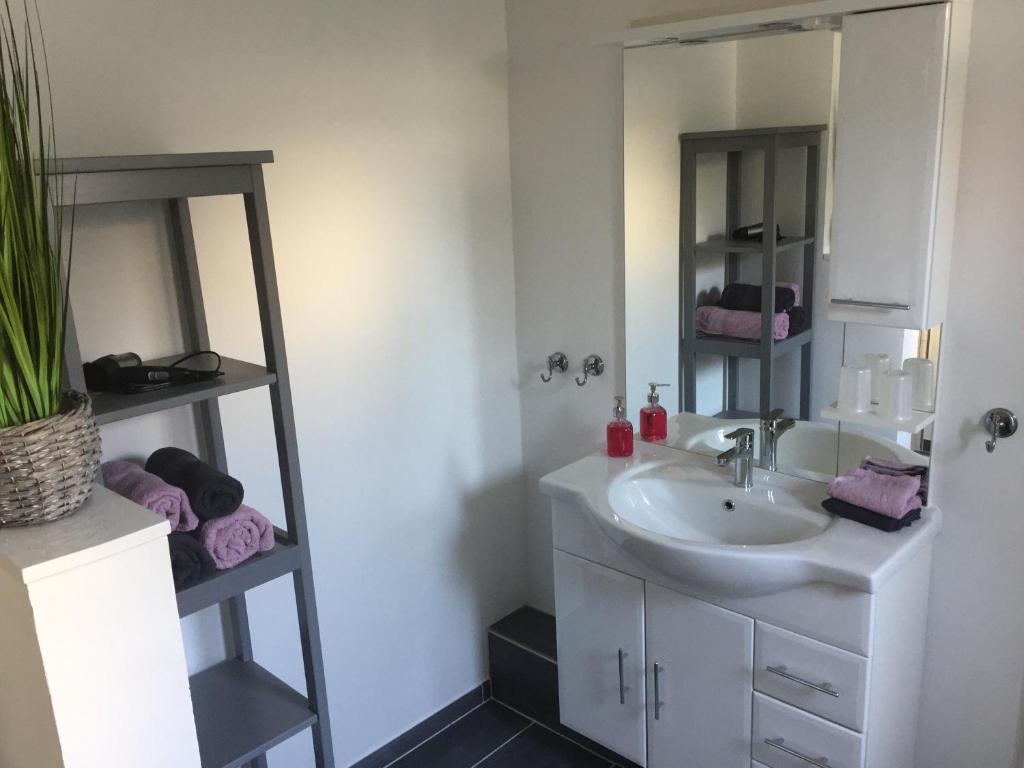 ein Bad mit einem Waschbecken und einem Spiegel in der Unterkunft MeFo in Heiligenhafen