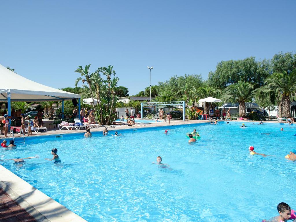 a group of people swimming in a swimming pool at Kamemi Village & Camping in Ribera