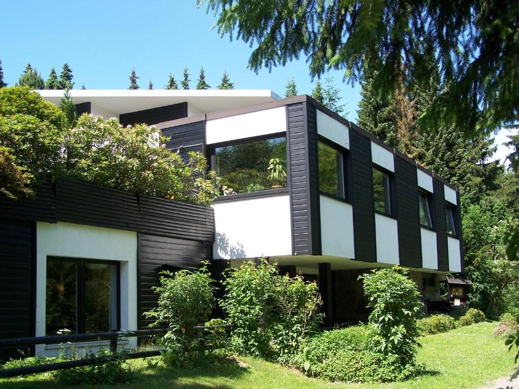 uma casa a preto e branco com árvores em Hotel Haus am Hochwald em Hahnenklee-Bockswiese