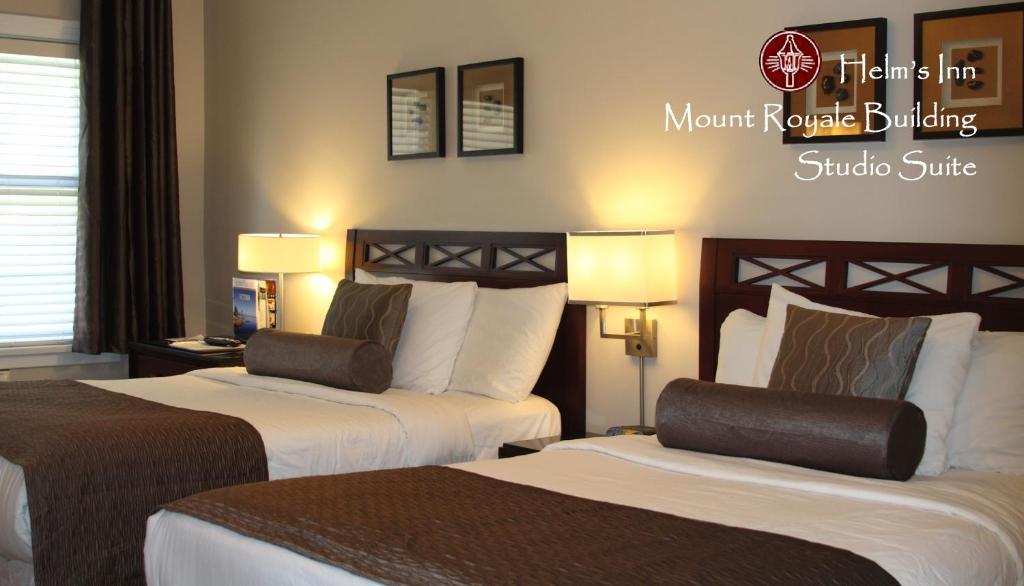um quarto de hotel com duas camas e duas lâmpadas em Helm's Inn em Victoria