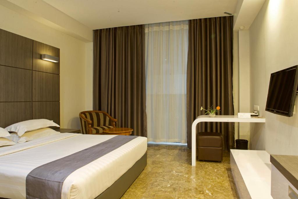 a hotel room with a bed and a television at Dreamtel Jakarta in Jakarta