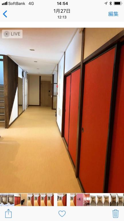 an empty hallway with red doors in a building at Oyado Zen in Kusatsu