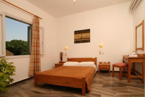 1 dormitorio con cama, escritorio y ventana en Nautilus Apartments, en Sissi