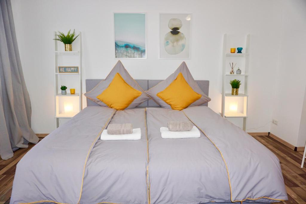 una camera da letto con un grande letto con cuscini gialli di MH Apartment a Königsbrunn