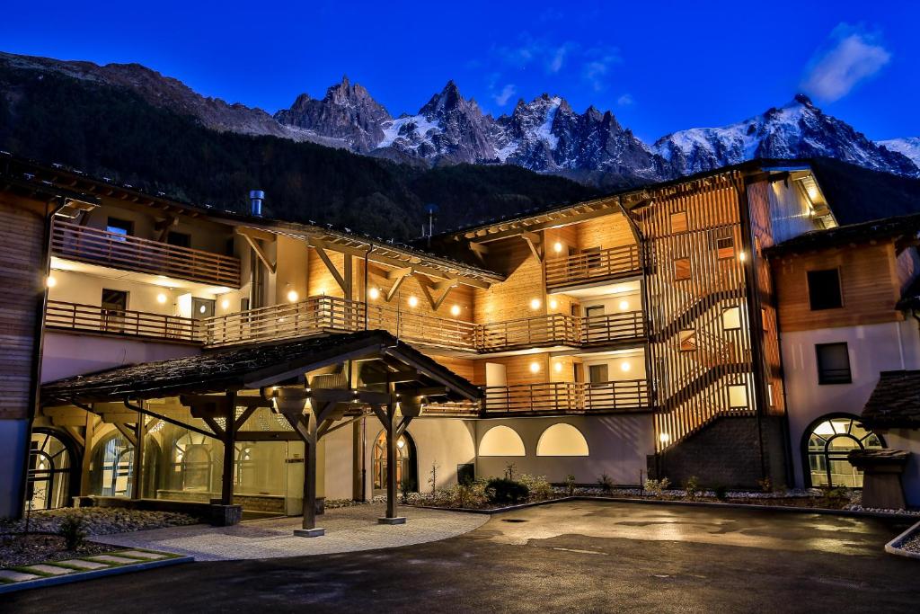 a building with a mountain in the background at Appartement 123 La Cordée in Chamonix