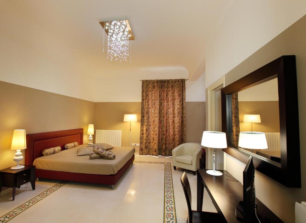 ein Schlafzimmer mit einem Bett und einem großen Spiegel in der Unterkunft Abatellis Luxury in Palermo