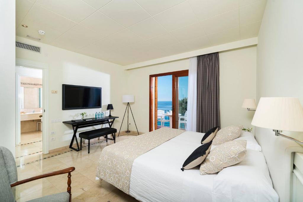 a bedroom with a bed and a desk and a television at Hotel Santa Marta in Lloret de Mar