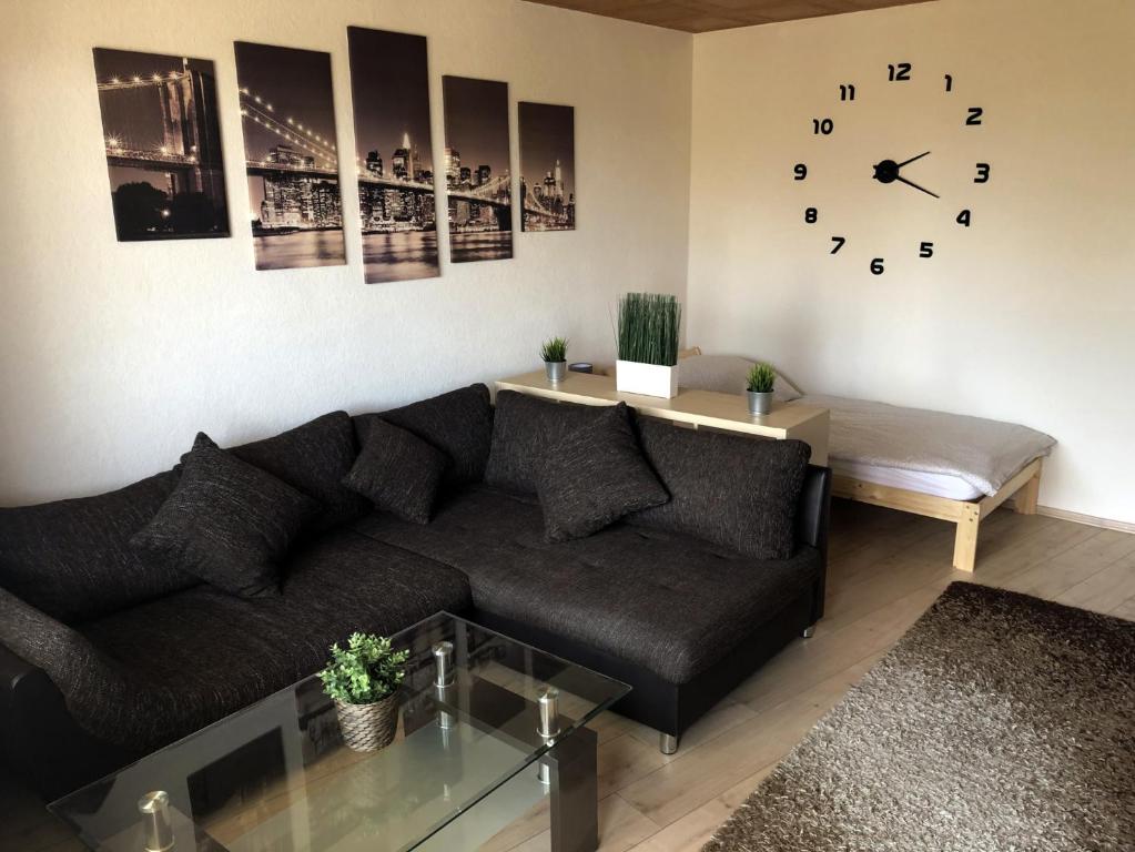 a living room with a couch and a clock on the wall at Gemütliche Ferienwohnung mit Smart-TV in Kerpen