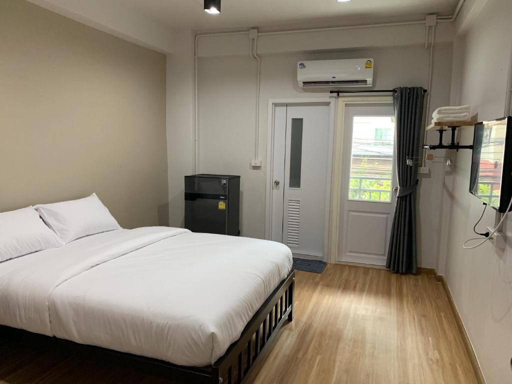 a bedroom with a large white bed and a window at 9TY hotel (ninety hotel) in Bangkok
