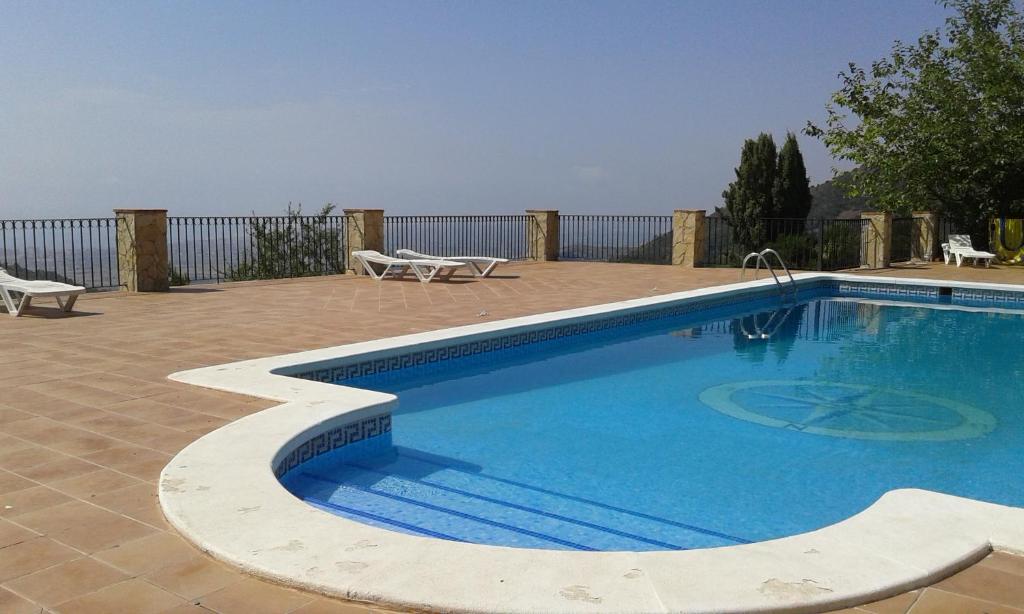 a swimming pool with two chairs and a fence at RIVIERA in Benicàssim