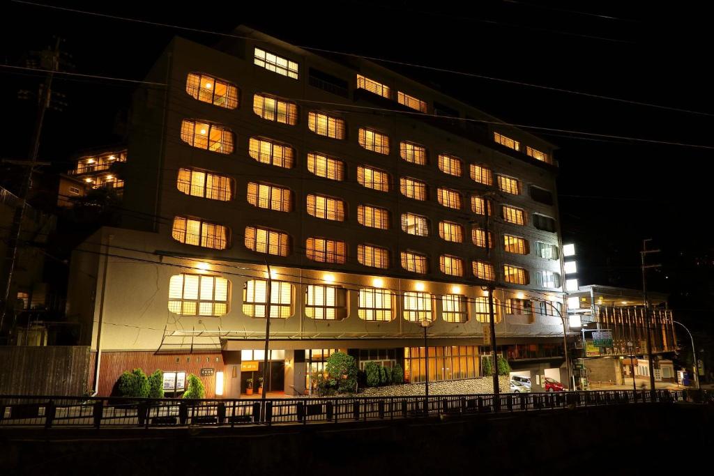 a large building with lit windows at night at Arima Gyoen in Kobe
