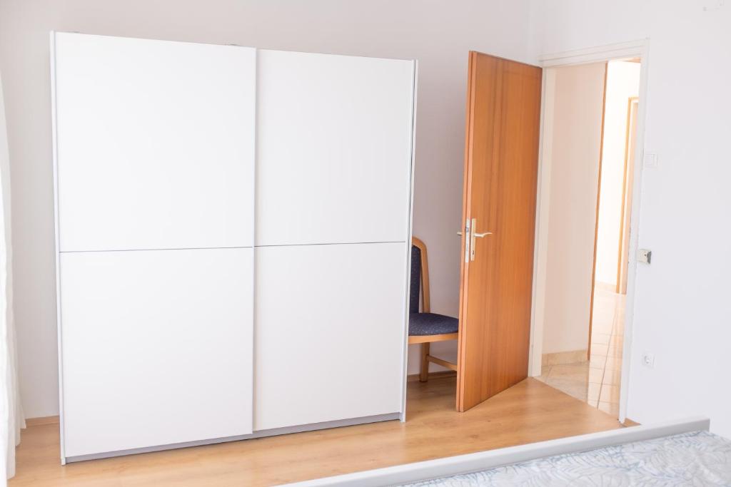 a white wardrobe in a room with a mirror at Apartment Sv. Marak in Risika