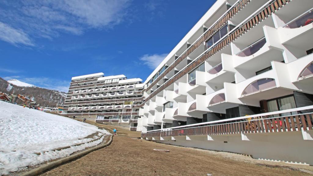 a large white building with snow in front of it at Cortina - Cimes & Neige in Puy-Saint-Vincent