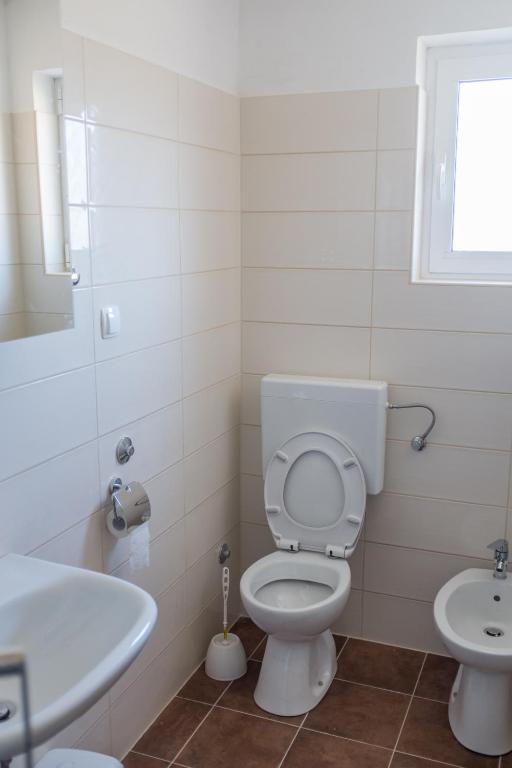 a bathroom with a white toilet and a sink at Apartment Sv. Marak in Risika
