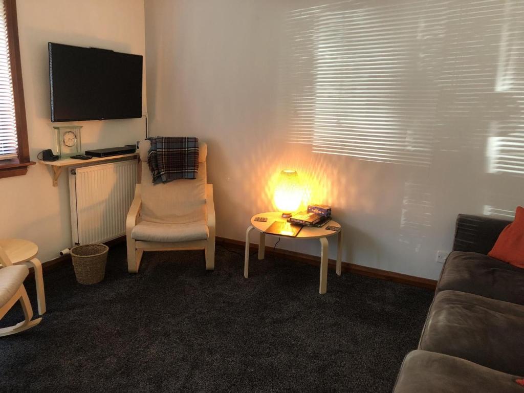 ein Wohnzimmer mit einem Sofa und einem Tisch mit einer Lampe in der Unterkunft NEW Super 2BD Flat near Dalkeith Town Centre in Dalkeith