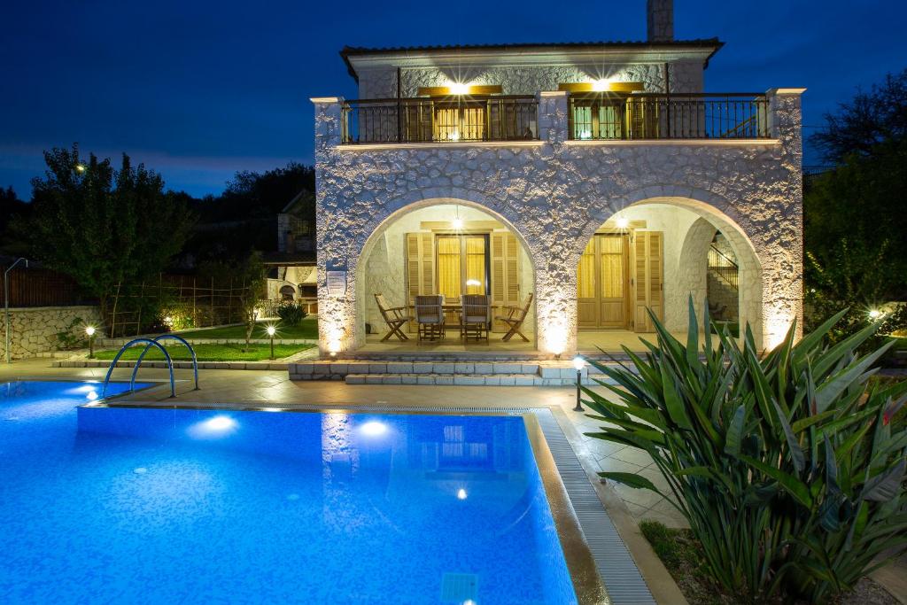 a villa with a swimming pool at night at Villa Rubini in Lefkada Town