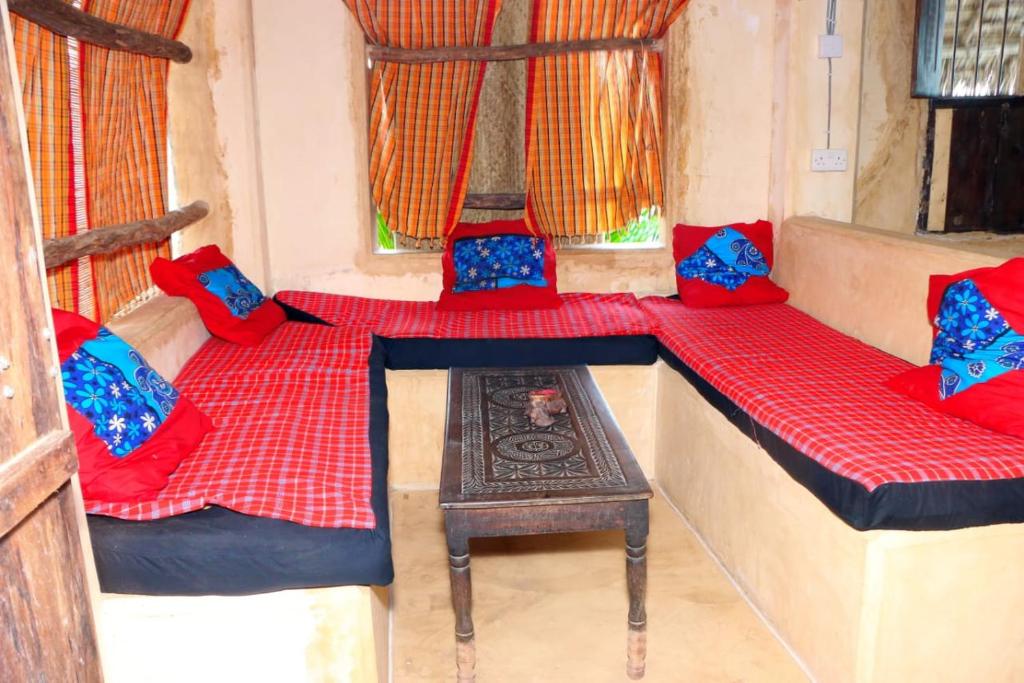 a room with two beds and a table at Wildebeeste Lamu in Lamu