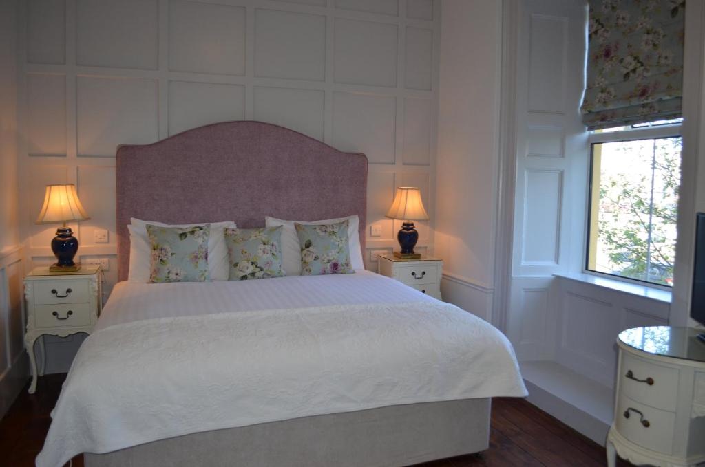 um quarto com uma cama grande e 2 mesas de cabeceira em The Listowel Arms Hotel em Listowel